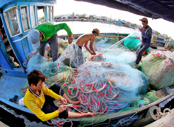 Ngư dân chuẩn bị ngư cụ ra khơi. Ảnh: BÁ THI