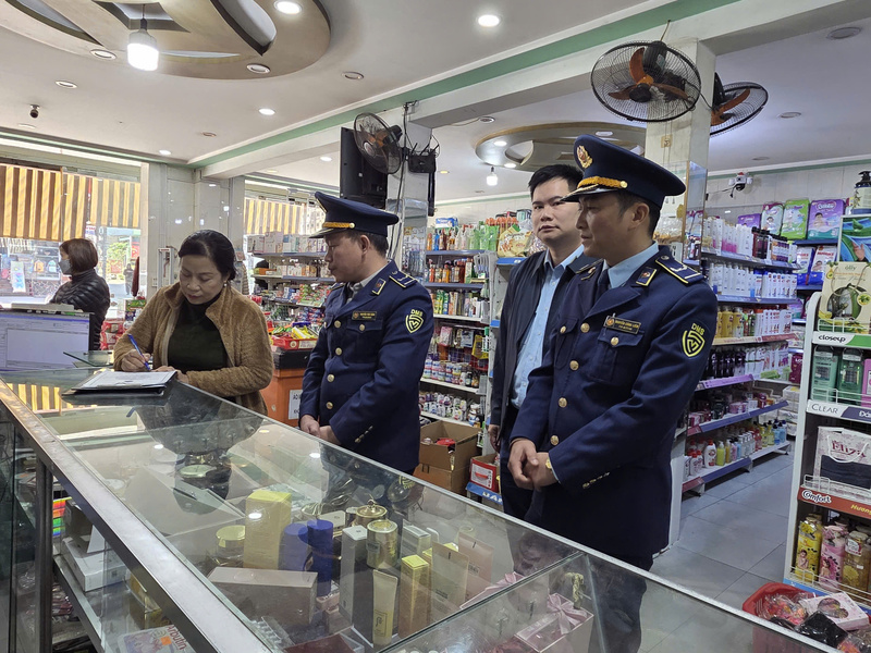 Lực lượng Quản lý thị trường Tuyên Quang tuyên truyền và hướng dẫn các hộ kinh doanh ký cam kết chấp hành quy định về an toàn thực phẩm, niêm yết giá và kinh doanh hàng hóa rõ nguồn gốc. Ảnh: Văn Thi