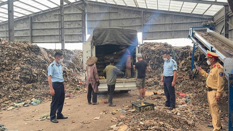 Lực lượng chức năng giám sát tiêu hủy hàng hóa vi phạm. Ảnh: Cục Quản lý và Phát triển thị trường trong nước