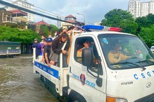 Cảnh sát giao thông Hà Nội hỗ trợ người dân di chuyển an toàn qua điểm ngập úng