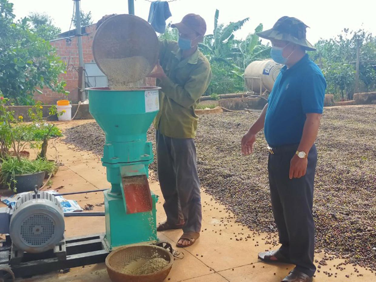 Ông Nguyễn Văn Long (bìa phải; làng U Diêp, xã Kông Htok, huyện Chư Sê) bên máy nghiền thức ăn gia súc của gia đình.