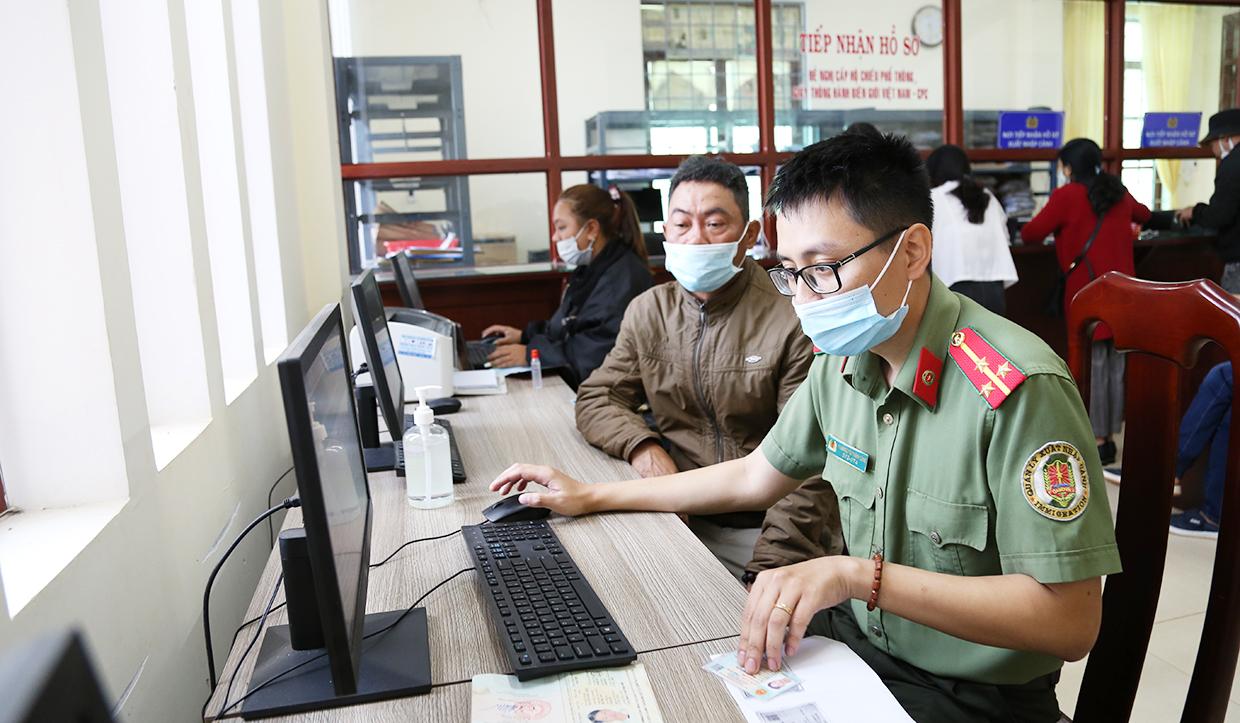 Cán bộ Phòng Quản lý xuất nhập cảnh (Công an tỉnh) hướng dẫn người dân thực hiện tờ khai điện tử. Ảnh: Thúy Trinh