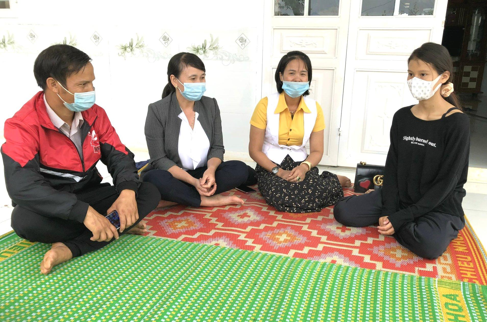 Cán bộ UBND xã ADơk, huyện Đak Đoa trò chuyện với em Nech (bìa phải), làng ADơk Kông, huyện Đak Đoa. Ảnh: Đinh Yến