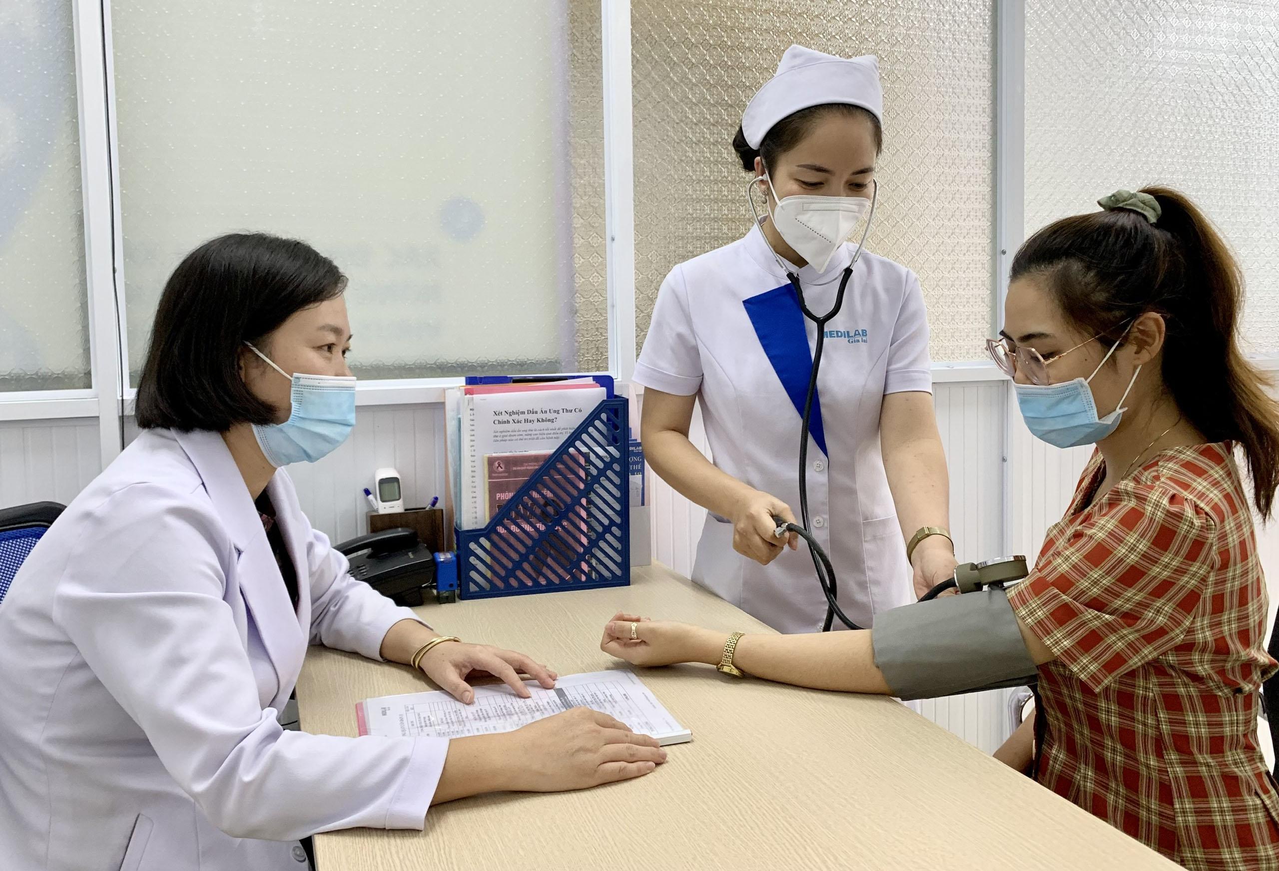 Nhân viên Trung tâm Xét nghiệm Y khoa Medilab Gia Lai thăm khám sức khỏe ban đầu cho người dân trước khi thực hiện lấy mẫu xét nghiệm dấu ấn ung thư. Ảnh: Như Nguyện