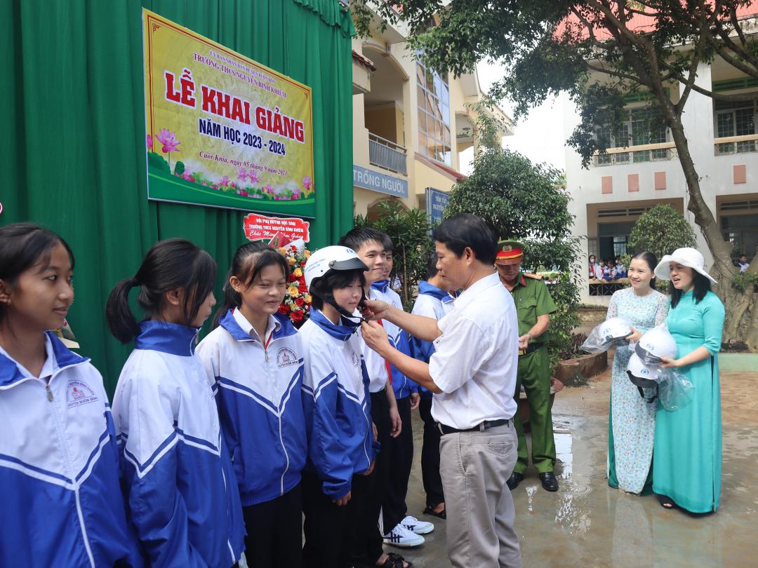 Ông Bùi Văn Ngọc, Chánh Văn phòng Ban An toàn giao thông tỉnh tặng mũ bảo bảo hiểm cho học sinh Trường THCS Nguyễn Bỉnh Khiêm (huyện Buôn Đôn).