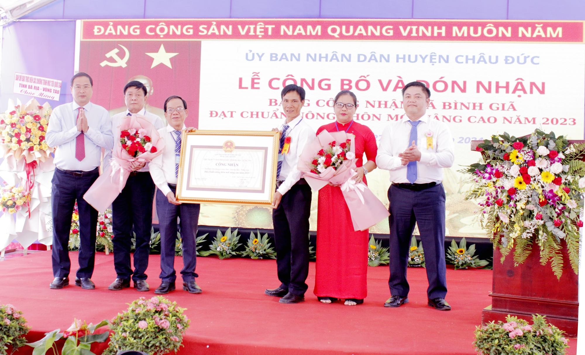 Ông Vũ Ngọc Đăng, Phó Chánh văn phòng điều phối xây dựng NTM tỉnh, Chi cục trưởng Chi cục Phát triển nông thôn tỉnh và ông Nguyễn Tấn Bản, Chủ tịch UBND huyện Châu Đức trao bằng công nhận xã Bình giã đạt chuẩn NTM nâng cao và tăng hoa chúc mừng cho đại diện xã.