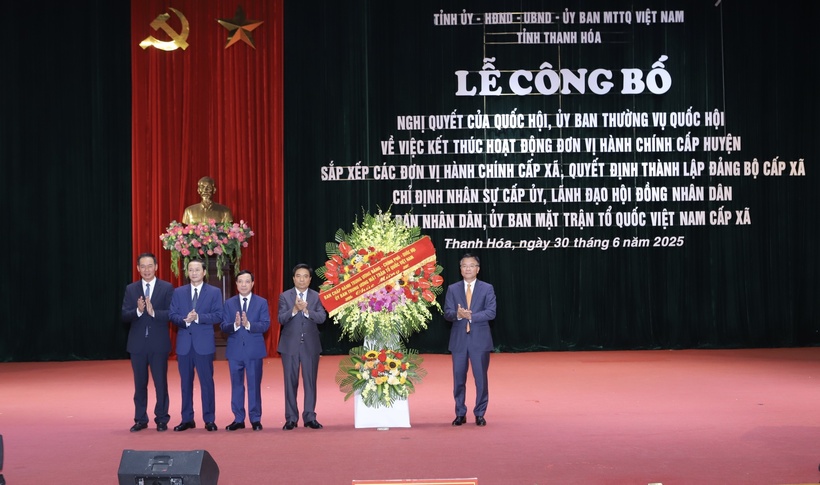 Phó Thủ tướng Chính phủ Lê Thành Long trao Nghị quyết của Ủy ban Thường vụ Quốc hội về việc thành lập các xã, phường của tỉnh Thanh Hóa cho lãnh đạo tỉnh Thanh Hóa và tặng hoa chúc mừng. Ảnh: Minh Hiếu