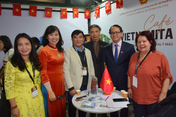 Đại sứ Việt Nam tại Chile Nguyễn Việt Cường (thứ hai từ phải sang) và bà Ngô Thu Hương - Tham tán Thương mại, Trưởng Thương vụ Việt Nam tại Chi Lê (thứ hai từ trái sang) chụp ảnh chung với đại biểu, khách tham quan Hội chợ tại Gian hàng