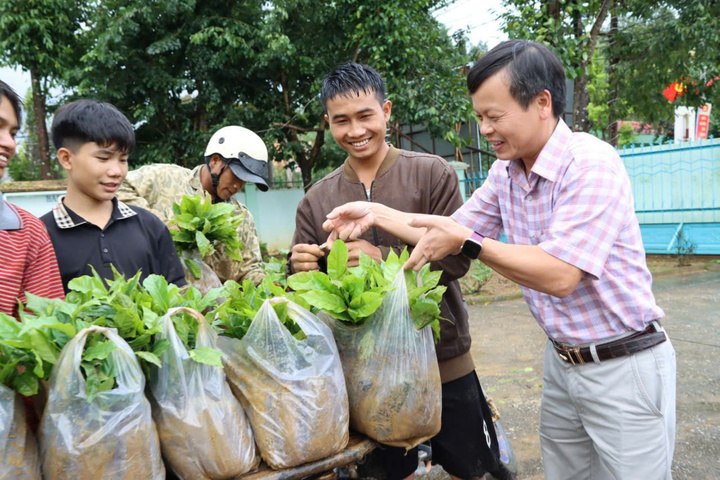 Ông Trần Quốc Huy, Chủ tịch UBND xã Tu Mơ Rông nhận cây cà phê catimo từ các đơn vị, doanh nghiệp và trao tặng cho người dân. Ảnh: Bình An