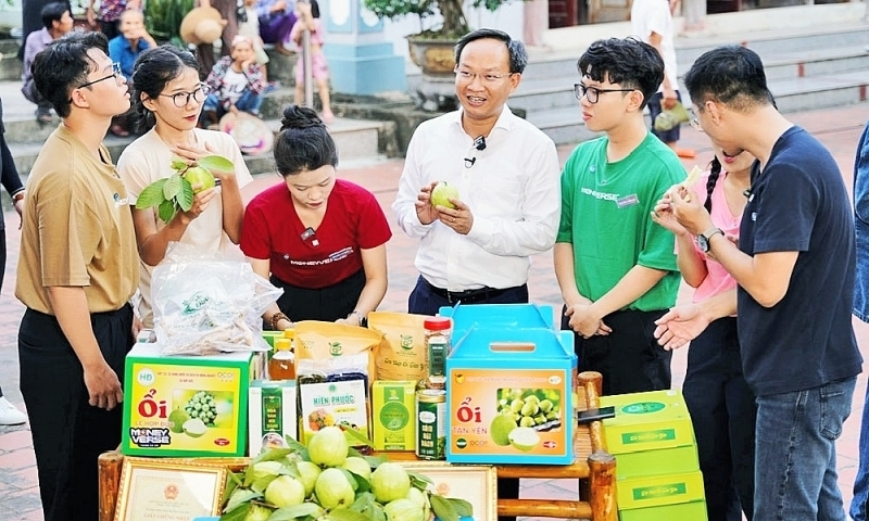 Ông Phạm Văn Thịnh (áo trắng) đang giới thiệu nông sản cho người dân. Ảnh: BN