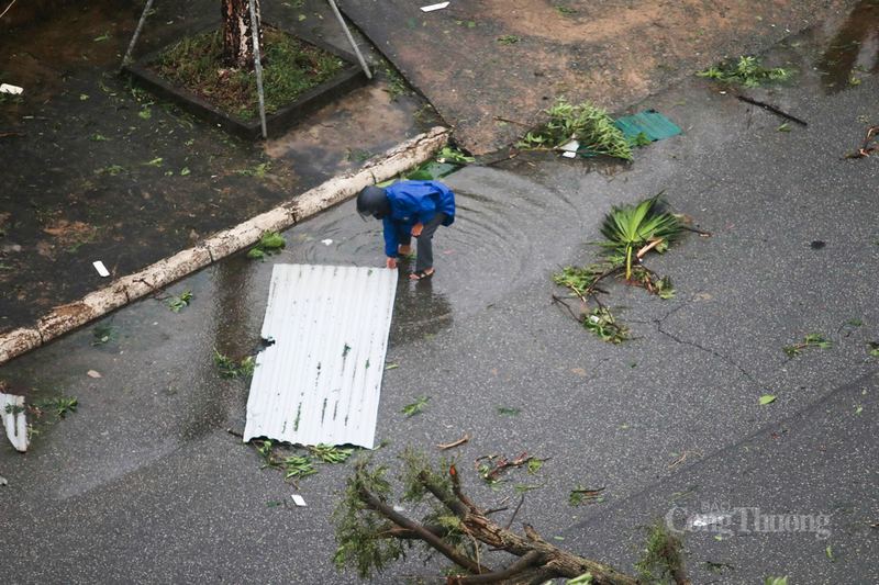 Sáng sớm, người dân tất bật đi nhặt lại mảnh tôn bị gió cuốn bay.