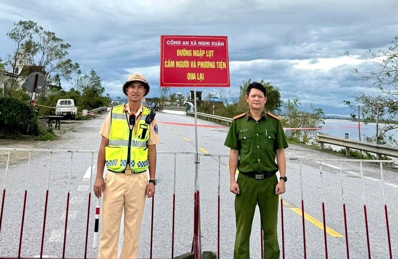 Lực lượng chức năng cắm biển cảnh báo, cấm người và phương tiện qua lại vùng ngập lụt. Ảnh: Phúc Sơn