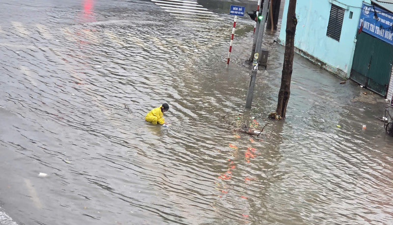 Công nhân móc rác bị kẹt miệng cống thoát nước.