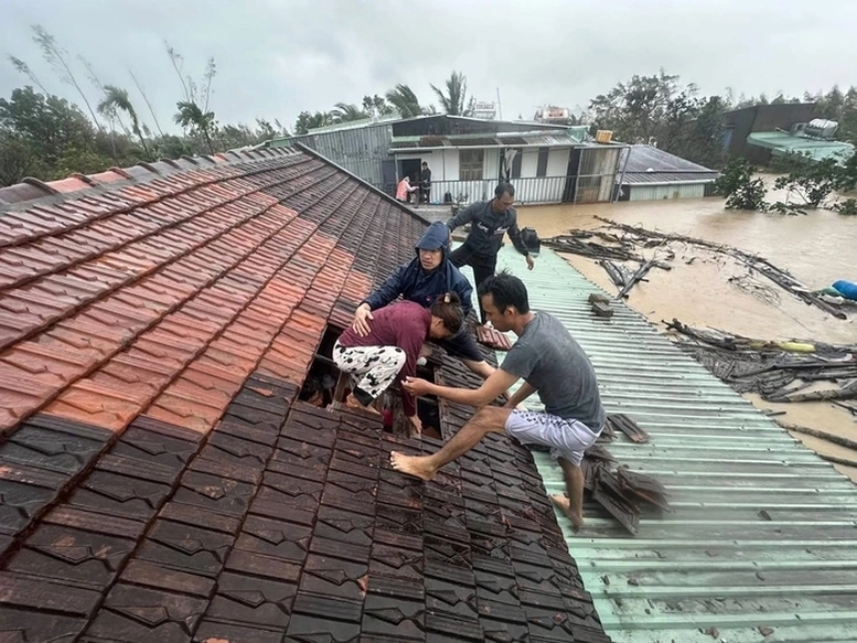 Người dân Quy Nhơn được đội cứu hộ dỡ mái nhà cứu ra ngoài - Ảnh: VGP