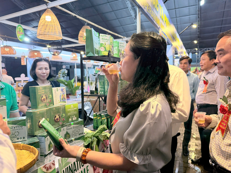 Bà Đỗ Thị Minh Trâm - Phó Cục trưởng Cục Đổi mới sáng tạo, Chuyển đổi xanh và Khuyến công - trải nghiệm sản phẩm tại gian hàng thực phẩm bảo vệ sức khỏe. Ảnh: Minh Anh