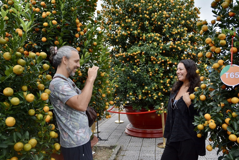 Chị Natasha Villa (30 tuổi, du khách Mỹ) bày tỏ: “Không khí ngày hội rất sôi động và người dân rất thân thiện, sẵn sàng giới thiệu giúp tôi hiểu rõ hơn ý nghĩa của cây quật trong ngày Tết của Việt Nam”. Ảnh: Ngọc Thảo