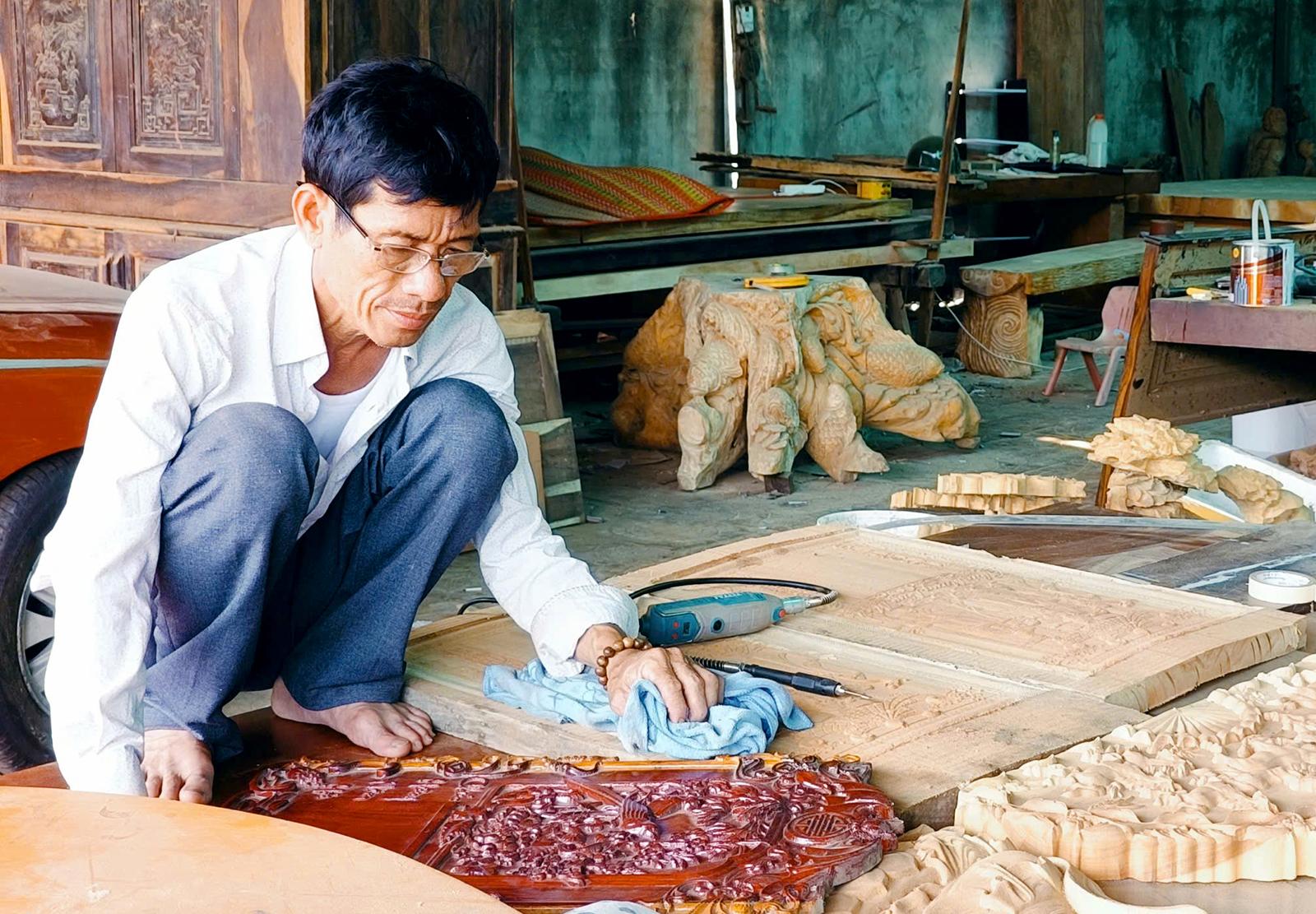 Ông Nguyễn Ngọc Giào hoàn thiện đốc lịch gỗ. Ảnh: KIỀU DIỄM