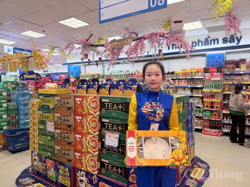 Nhân viên tiếp thị giới thiệu các dòng sản phẩm Tết với bao bì rực rỡ và chính sách giá ưu đãi tại siêu thị. Ảnh: Minh Anh.