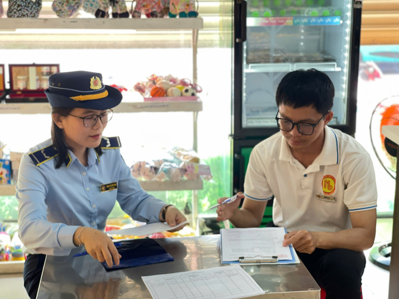 Tổ công tác số 10 thuộc Chi cục Quản lý thị trường Gia Lai hướng dẫn đại diện Cửa hàng đặc sản Hương Việt - Trung tâm thương mại Hoàn Cầu ký cam kết an toàn thực phẩm.