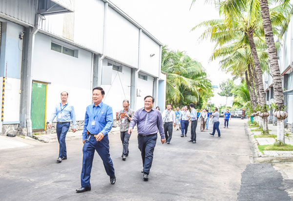 Doanh nhân Cù Văn Thành- Giám đốc Công ty TNHH Chế biến dừa Lương Quới (KCN An Hiệp, xã Phú Túc) dẫn đoàn khách tham quan dây chuyền sản xuất sản phẩm dừa tại công ty.