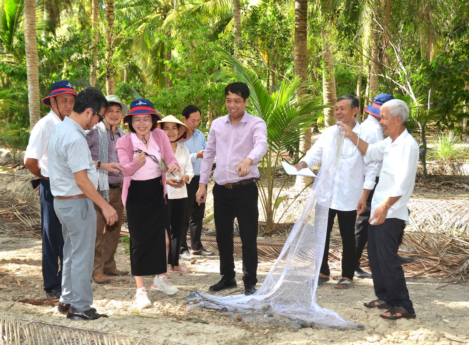 Đoàn kiểm tra vườn dừa hộ ông Huỳnh Thiên Đường kết hợp nuôi cá và tôm càng xanh.