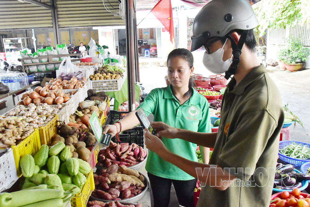Người tiêu dùng thanh toán bằng mã QR tại cửa hàng nông sản an toàn của ông Lê Ngọc Minh. Ảnh: MỸ NHÂN