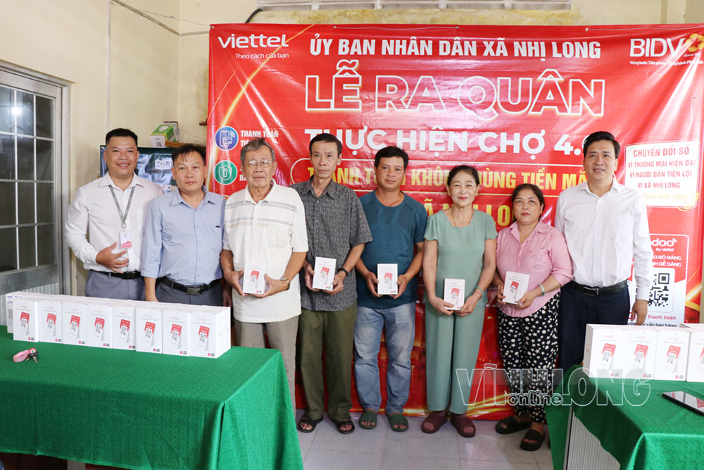 Đại diện Ngân hàng BIDV và Viettel Vĩnh Long trao thiết bị bảng mã QR và loa thông báo thanh toán cho tiểu thương. Ảnh: MỸ NHÂN